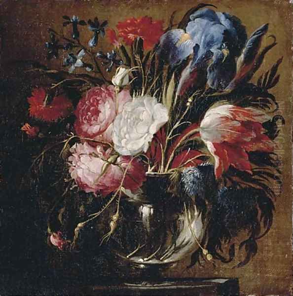 A tulip, carnations, roses, irises, bluebells and other flowers in a glass vase on a ledge - view 1