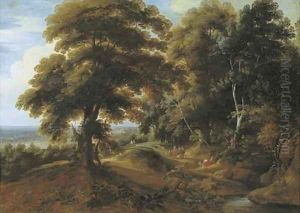 A wooded landscape with elegant figures on a path by Jacques d' Arthois