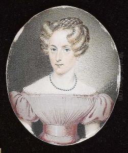 A Lady, Wearing A Pale Pink Dress With Matching Waistsash And White Lace Trim, Her Neck Adorned With Blue Beaded Necklace.