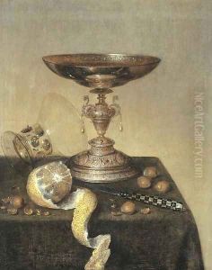 A silver tazza, an upturned roemer, a partly-peeled lemon, a knife and hazelnuts on a draped table by Maerten Boelema De Stomme