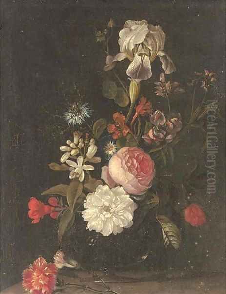 Carnations, narcissi, roses, an iris and other flowers in a glass vase on a ledge - view 1
