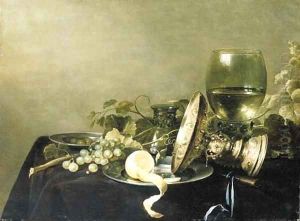A Vanitas still life with a partially peeled lemon, grapes and olives on pewter dishes, an overturned gold tazza, an upturned glass