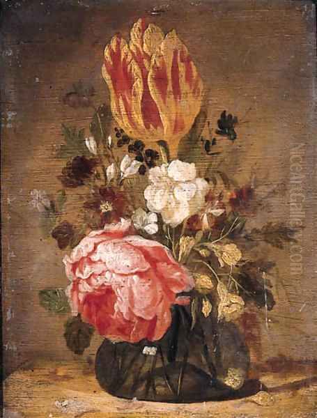 A tulip, a rose, a violet and other flowers in a glass vase on a wooden table - view 1