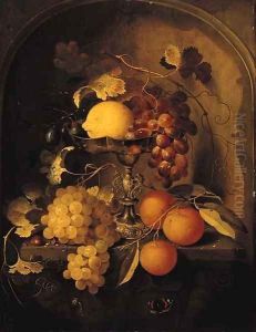 A lemon, grapes and plums on a tazza, with oranges, grapes and a hazelnut with a snail and a butterfly at a feigned sculpted stone niche