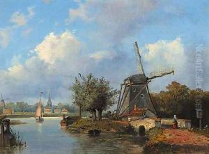 A windmill along a canal with a town in the distance