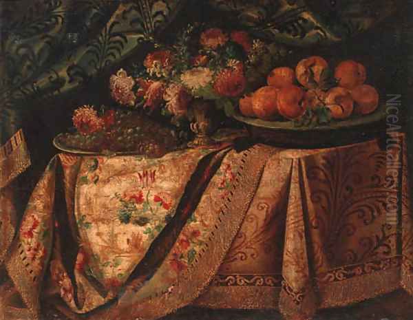 A vase of flowers with a salvers of grapes and oranges on a draped table - view 1