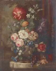 Roses, petunias, dahlias, campanulae and other summer flowers in an ornamental urn with bunches of grapes on a garden plinth