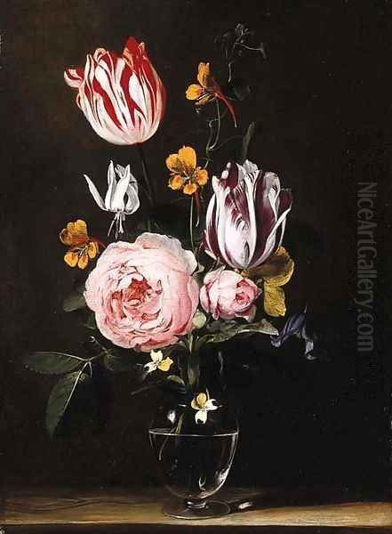 Roses, tulips, primroses and other flowers in a glass vase, on a wooden table - view 1