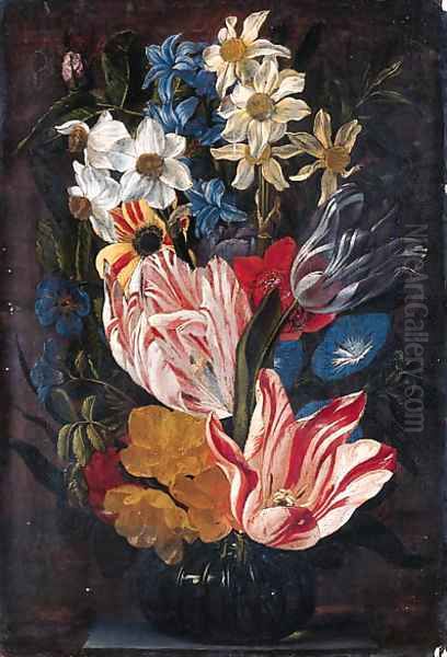 Tulips, roses, anemones, daffodils, hyacinths, morning glory and other flowers in a glass vase on a stone ledge - view 1