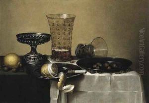 A peeled lemon, a knife and hazel-nuts on pewter plates by Willem Claesz. Heda