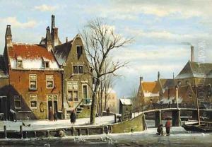 A view in a town with houses along a frozen canal, with townsfolk by a bridge