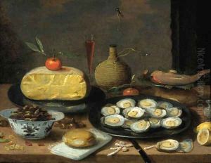A breakfast still life of oysters on a pewter plate, a half cheese, bread, hazelnuts, chestnuts, lemons, mandarins, a fish, a pepper pot