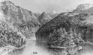 An wooded rocky River Landscape with elegant Company in a Boat rowing towards a Monument on an Island by Joseph Augustus Knip