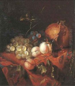 A pomegranate, grapes and peaches on a draped table