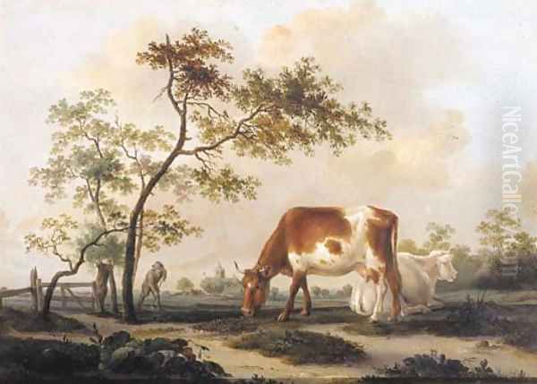 Cows on a farmyard with a village in the distance, in summer - view 1