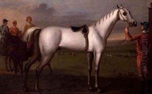 Groom holding a grey racehorse