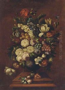 Flowers in a bowl next to pommegranites on a table