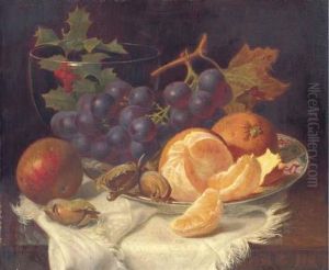 An Apple, Black Grapes, Two 
Oranges And Cob Nuts On Oriental Plate,with Holly In A Glass Vase, On A 
Wooden Table
