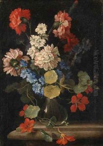 Carnations, nasturtiums and other flowers in a vase on a stone ledge