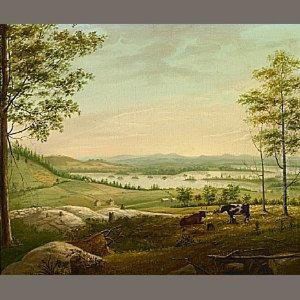 Cows Grazing On A Hillside With A View Of A Lake And Farmhouse
