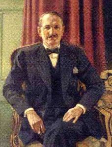 Portrait Of A Gentleman In A Pin-striped Suit, Holding A Cigar In His Right Hand, In An Interior