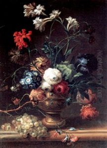 A Bouquet Of Flowers In A Decorated Vase And Grapes On A Table Top