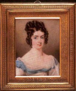 A Lady In White Dress Trimmed With Turquoise, With Lace Neckline, Matching Transparent Shawl Over Her Shoulder