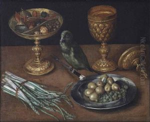 A Golden Tazza With Dates And Dried Fruits, A Golden Goblet And Cover, A Tin Plate With Olives And Capers And A Green Finch Seated On A Fork, Together With Asparagus On A Wooden Table