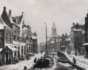 A View In A Dutch Town In Winter With Figures On A Frozen Canal