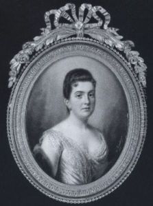 A Lady Wearing Yellow Dress With Lace Trim And Cap Sleeves, A Fur Stole Over Her Right Arm by Ernest de Landerset
