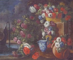 A Bowl Of Mixed Flowers With A Blue And White Jug And Other Flowers By A Fountain