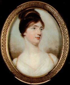 A Lady With Plaited Hair Piled High Upon Her Head And Entwined With Black Bandeau, Wearing Gold Trimmed White Dress