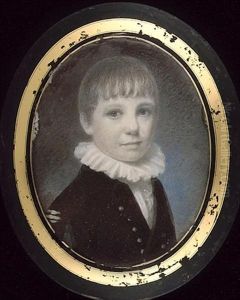 A Young Boy, Wearing Brown Coat With Silver Buttons And Frilled White Collar
