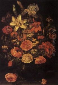Lilies, Irises, Roses And Other Flowers In A Glass Vase Beside Rose And Carnation Stems On A Wooden Table