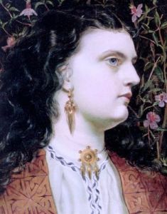Miss Sandys Wearing A Gold And Embroidered Jacket, Gold Earrings And A Brooch