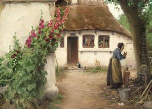 A woman at a farmhouse with red hollyhocks.
