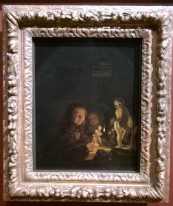 Two boys with plaster statuettes by the light of an oil lamp by Caspar Netscher