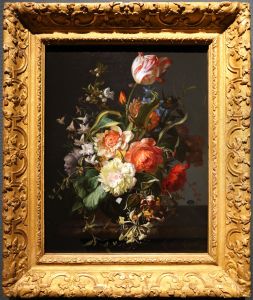 Flowers in a glass vase on a marble ledge